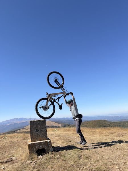 Bike lifted overhead by the survey marker